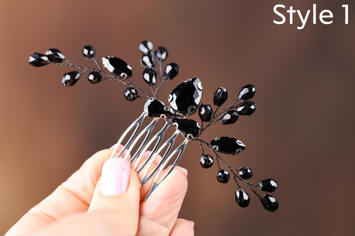 a hand holding a black flower shaped hair comb