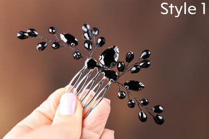 a hand holding a black flower shaped hair comb