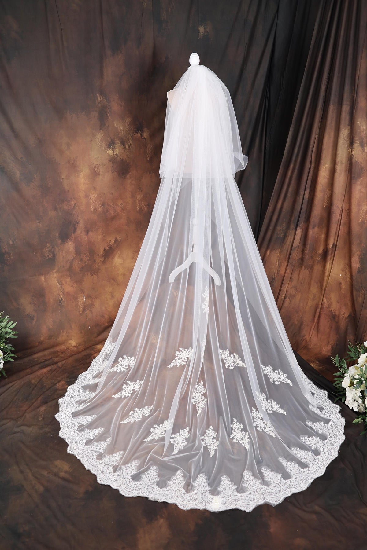 a wedding veil with white flowers on it