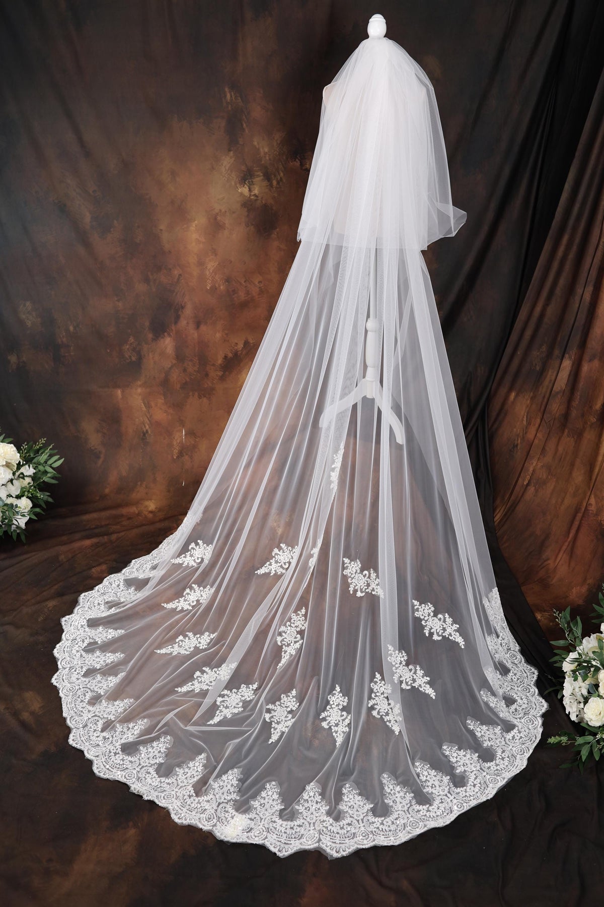 a wedding veil with white flowers on it