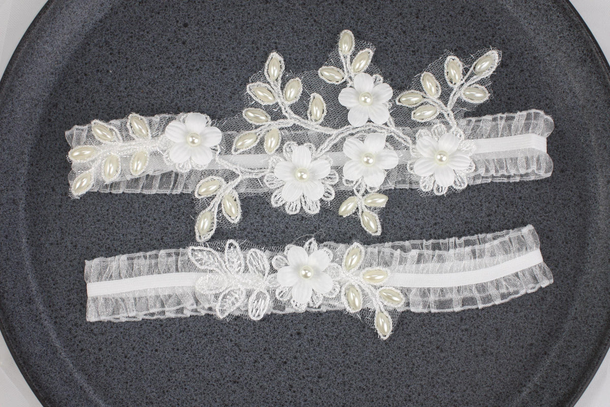 two garters with flowers and pearls on them