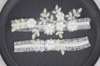 two garters with flowers and pearls on them
