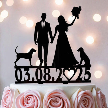 A silhouette of a bride and groom on a wedding cake topper, with a dog and a rose in the background.