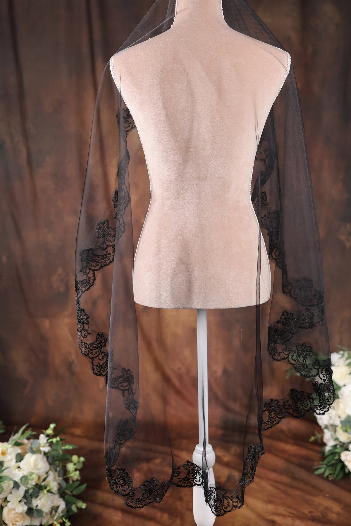 a white mannequin with a black veil on top of it