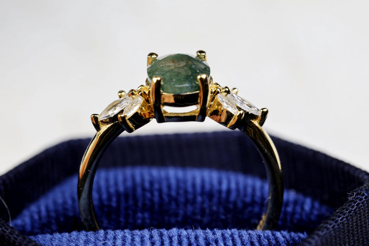 a close up of a ring with a green stone