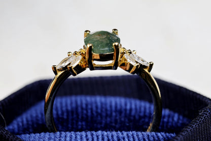 a close up of a ring with a green stone