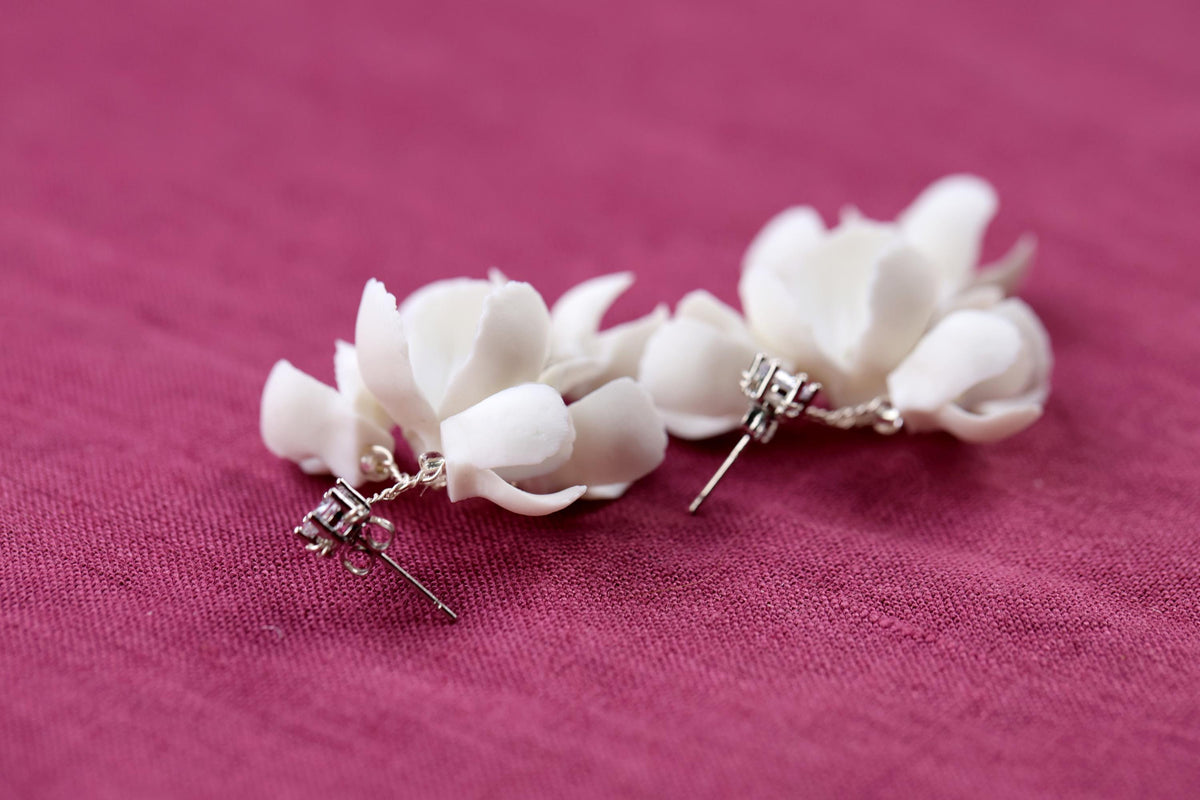 a pair of white flowers on a pink background