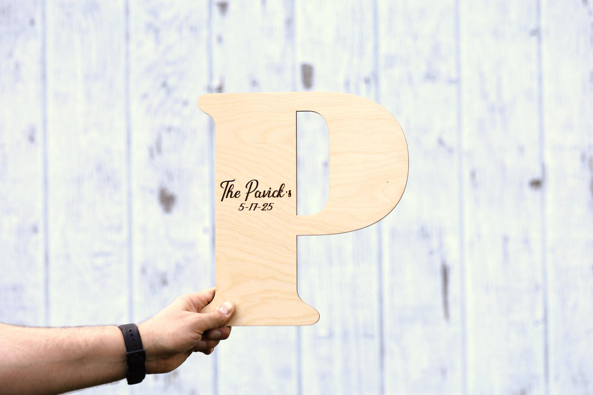 a person holding a wooden sign with the letter p on it