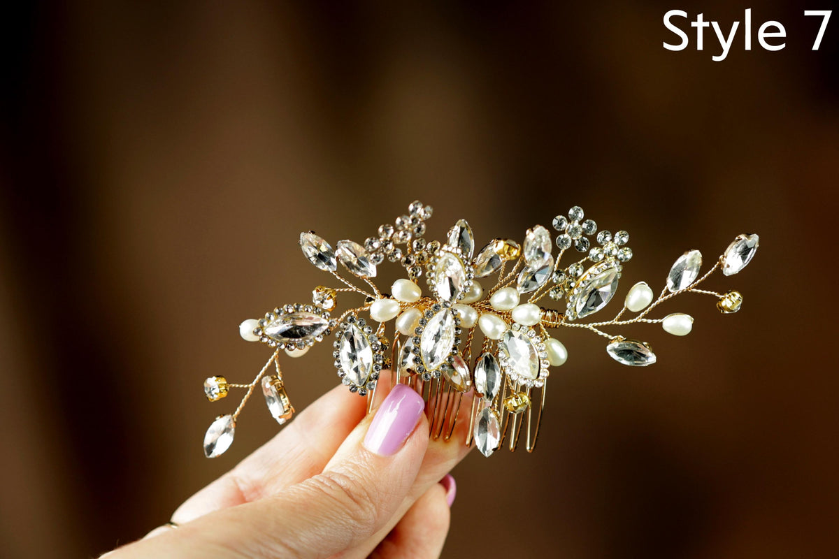 A hand holding a decorative hair accessory with a floral design and sparkling gemstones.