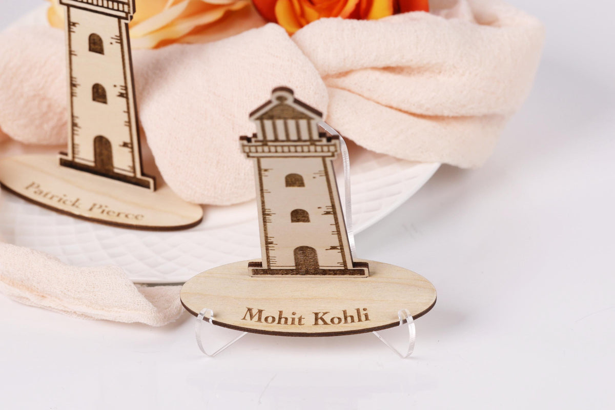 a wooden lighthouse with the name "Mohit Kohli" engraved on it, placed on a stand.