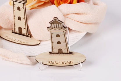 a wooden lighthouse with the name "Mohit Kohli" engraved on it, placed on a stand.