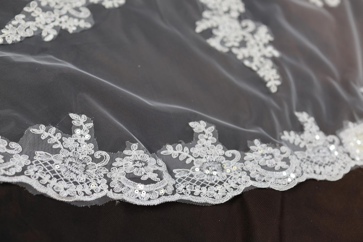 a close up of a white lace on a black cloth