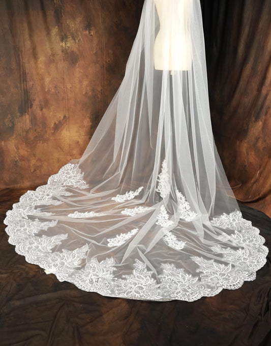 A white wedding veil with a lace-like trim, displayed on a mannequin.