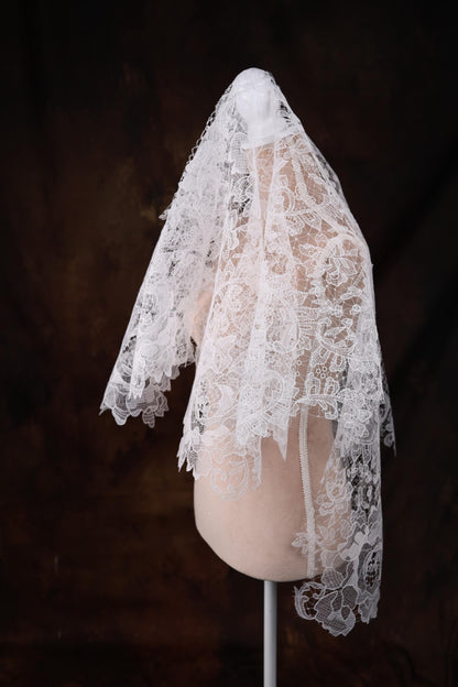 a mannequin with a white veil on top of it
