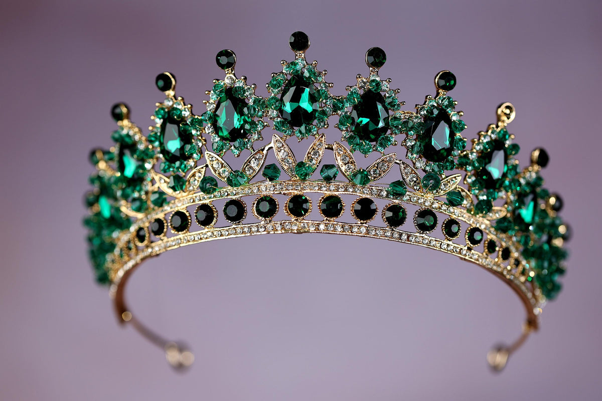 a tiara with green and black stones on it