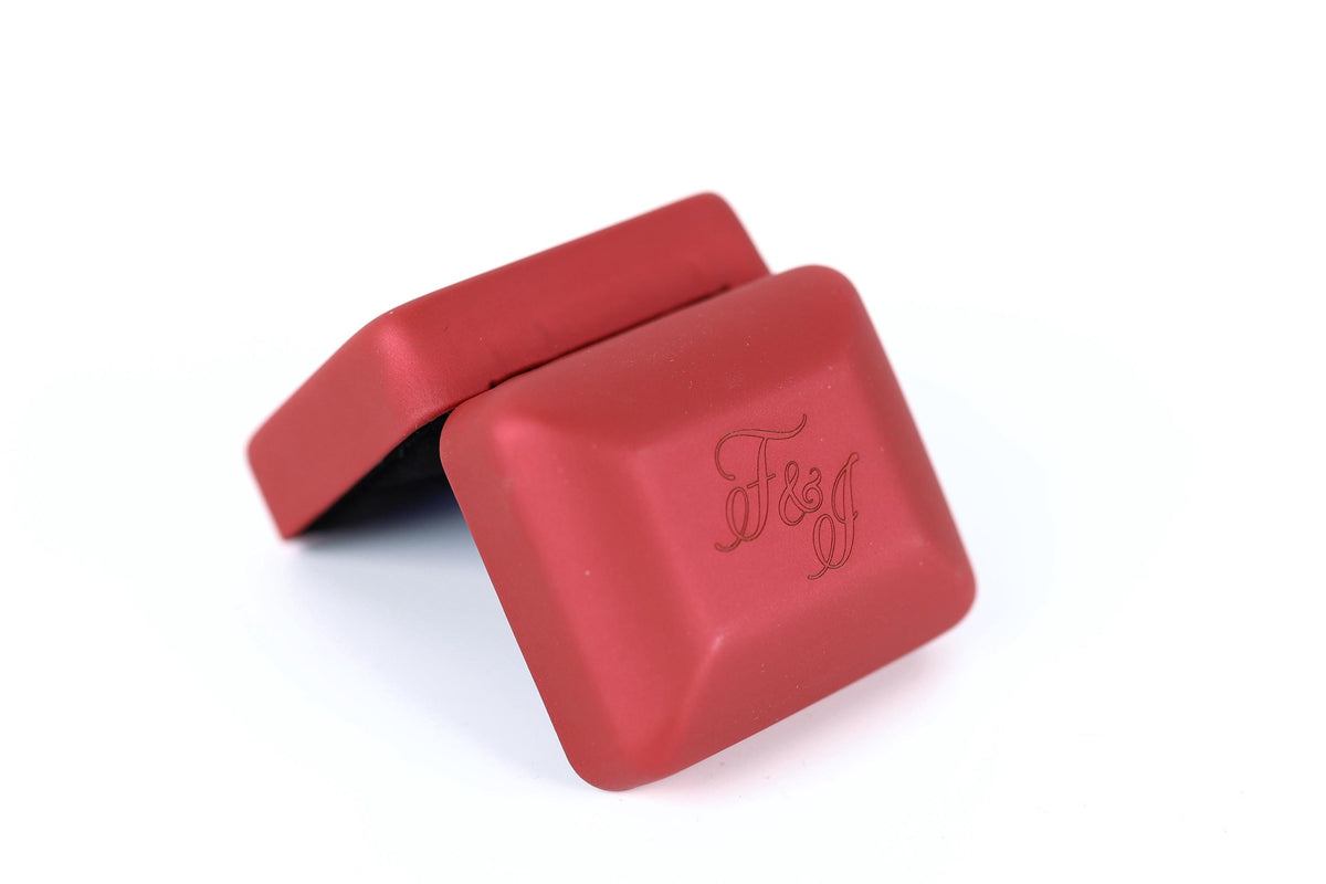 A red, square-shaped box with the word "F&J" embossed on it.