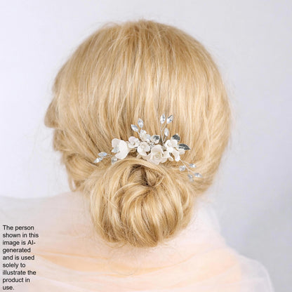 A close-up of a woman's blonde hair with a decorative hair accessory featuring white flowers.