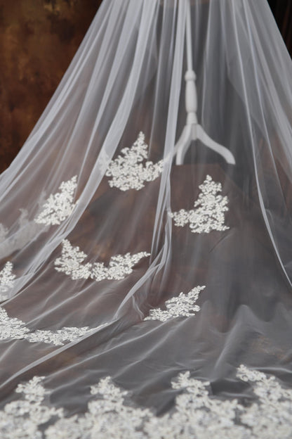 a wedding veil with white flowers on it