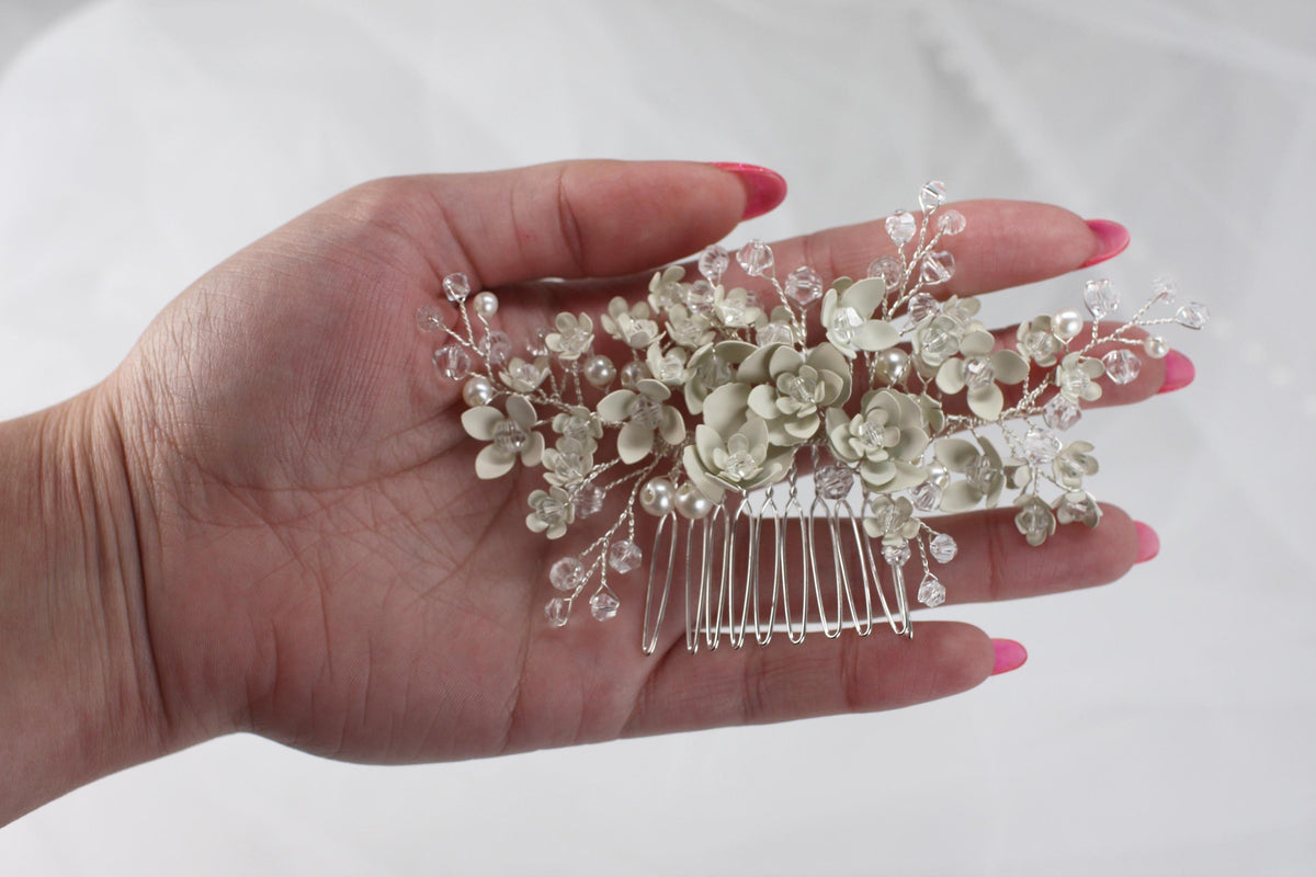 a woman's hand holding a hair comb with flowers on it