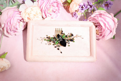a white plate topped with a piece of jewelry next to flowers