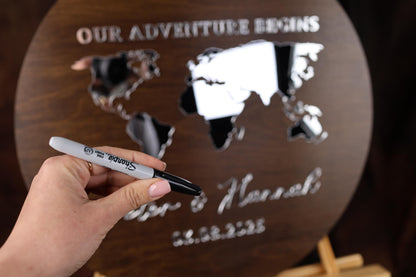 a person holding a pen in front of a world map