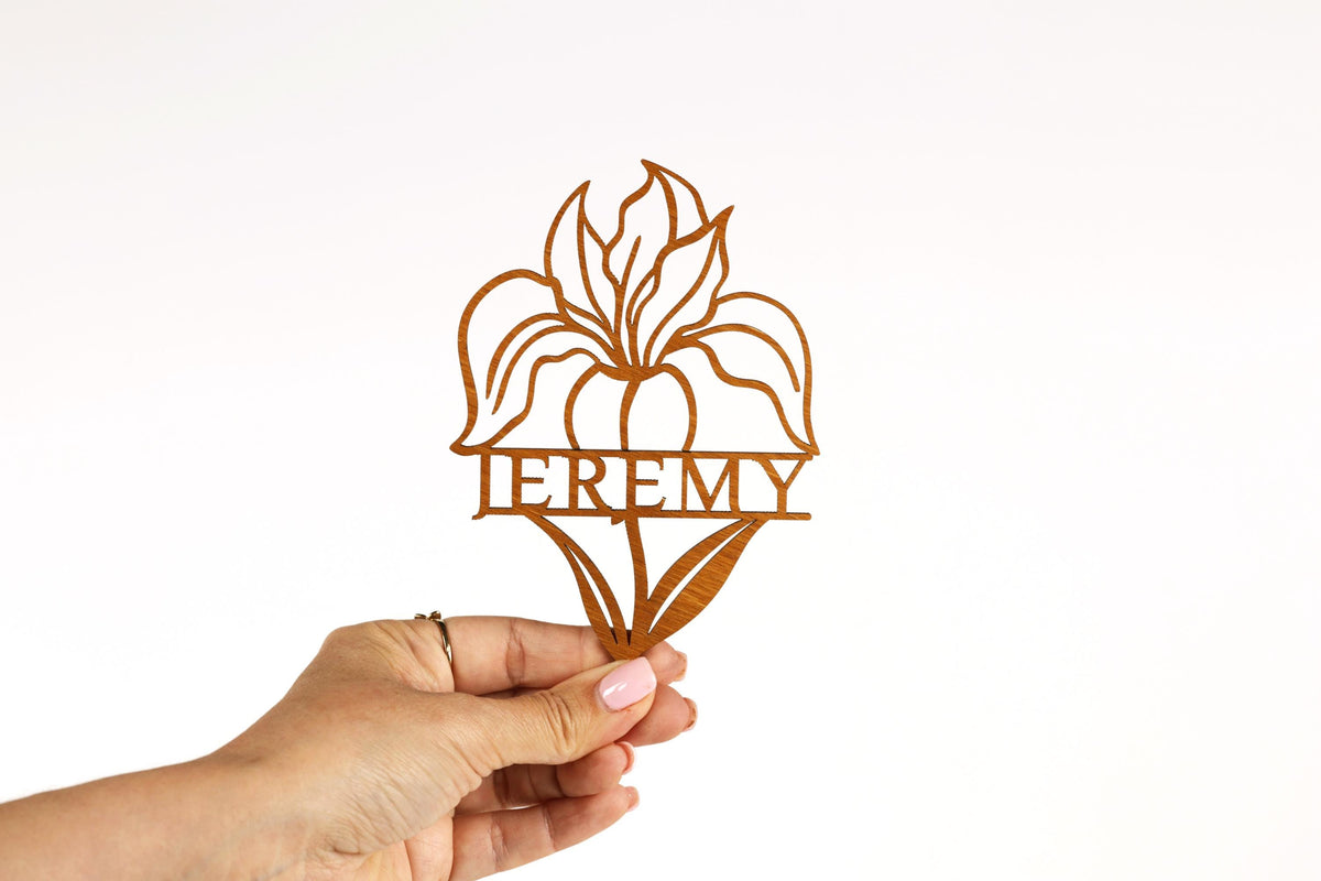 A hand holding a paper cutout of a flower with the word "ERMY" written on it.