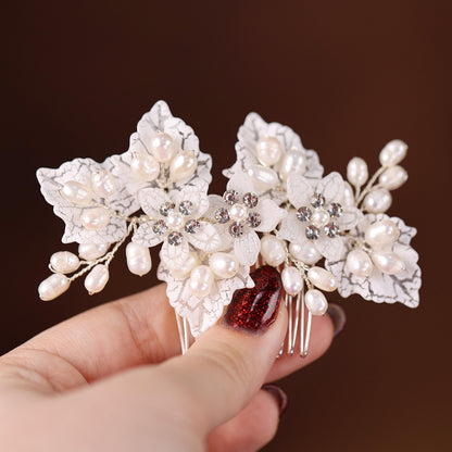 a person holding a piece of brooch with pearls on it