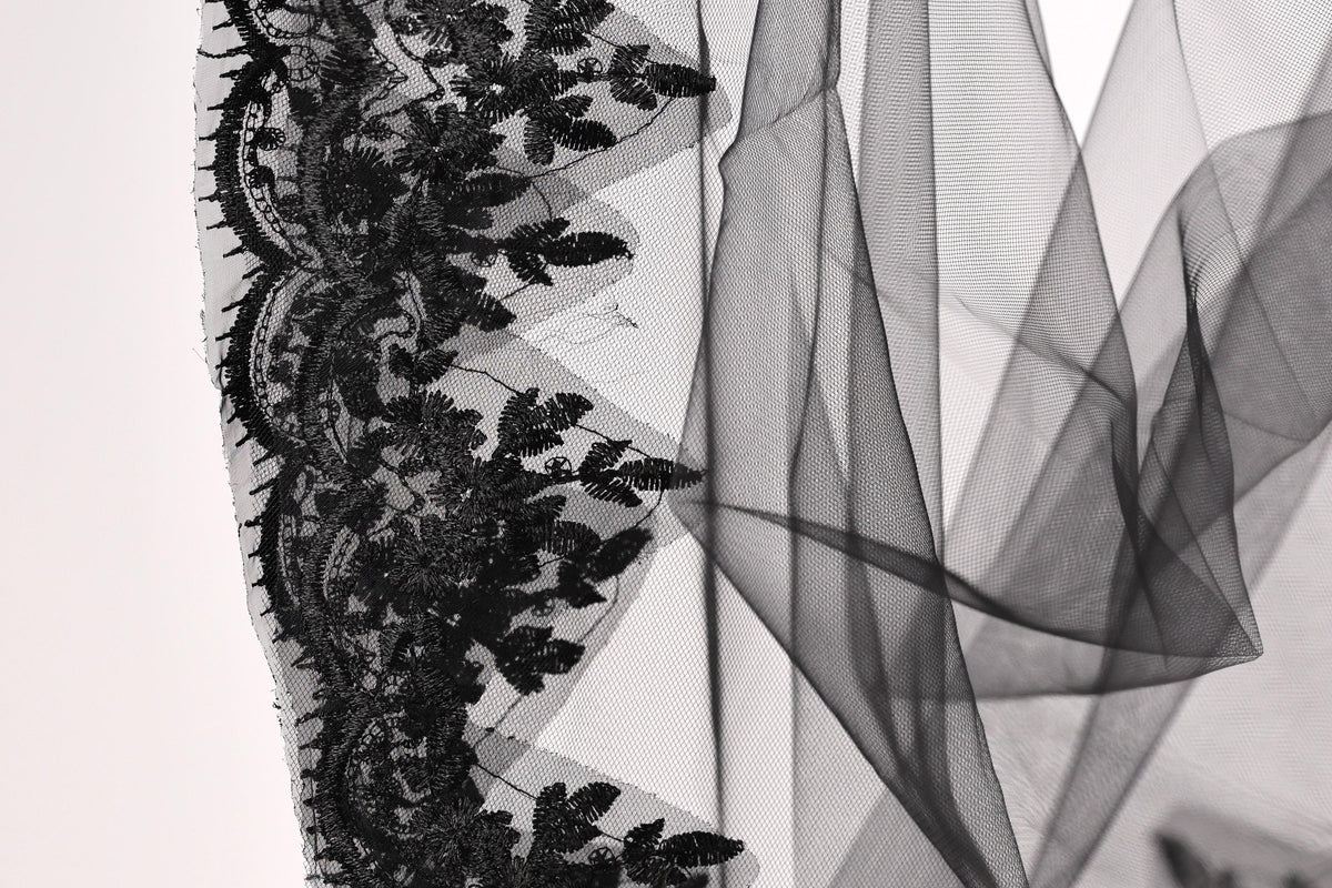 a close-up view of a delicate black lace trim with intricate floral patterns.