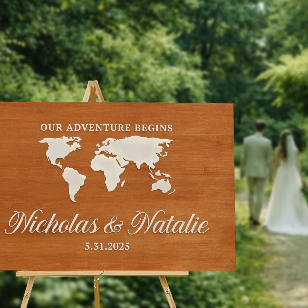 a wooden sign with a world map and the names "Nikolas & Natalie" written on it, along with the date "5.31.2025". In the background, there is a blurred image of a couple walking together.
