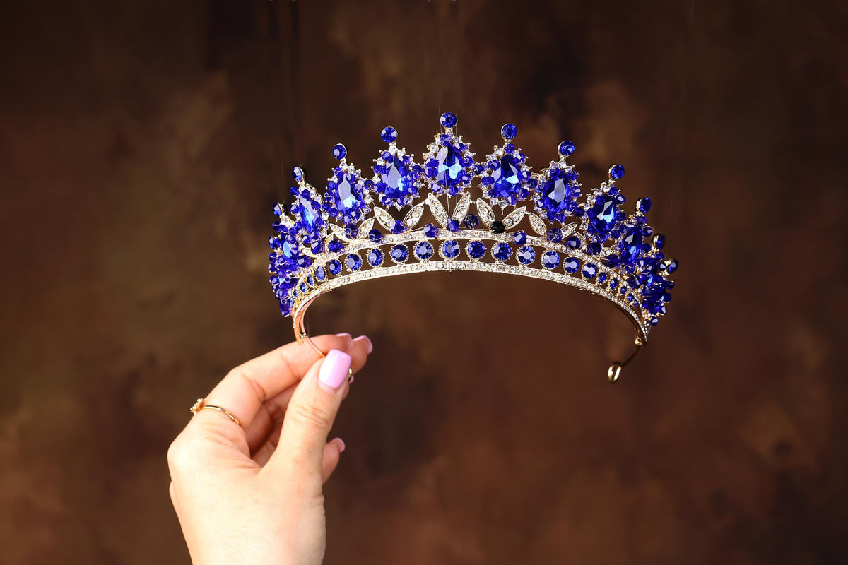 a woman is holding a tiara in her hand