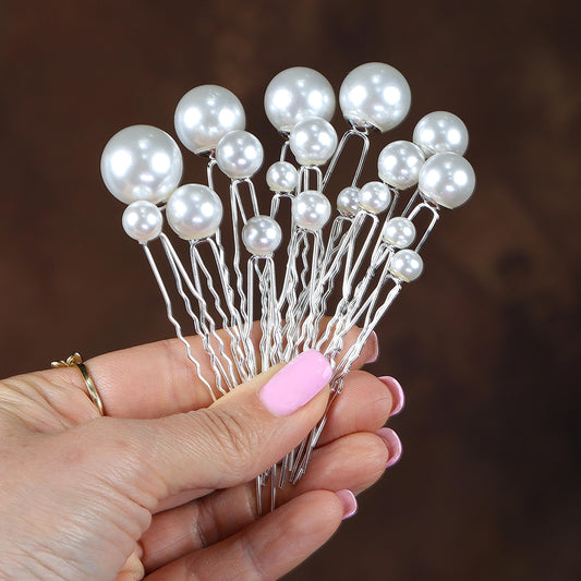 a hand holding a bunch of white pearls