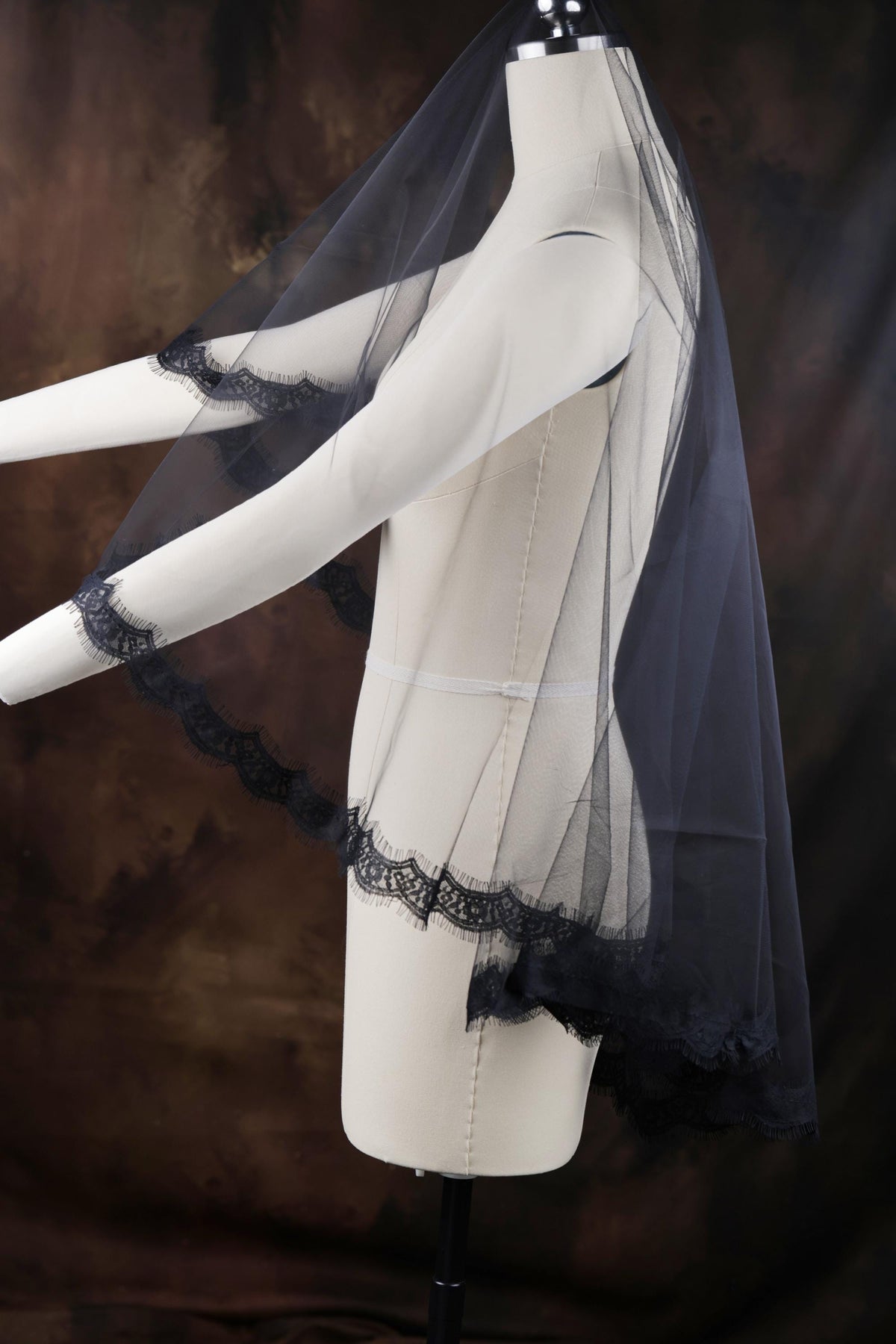 a white mannequin with a black veil on top of it