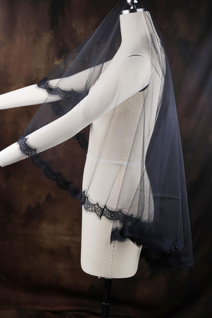 a white mannequin with a black veil on top of it