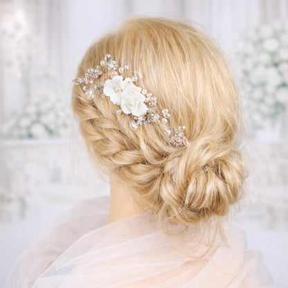 A close-up of a woman's blonde hair with a decorative hair accessory, such as a flower or crystal piece, in the back of her head.
