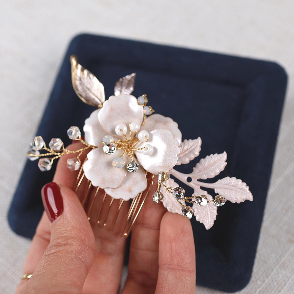 a woman is holding a hair comb with flowers on it