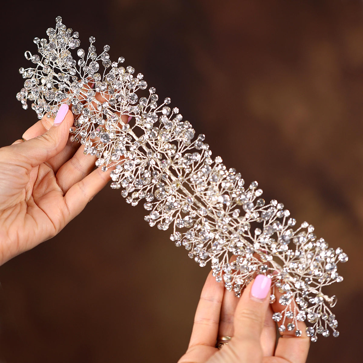 a close up of a person holding a tiara
