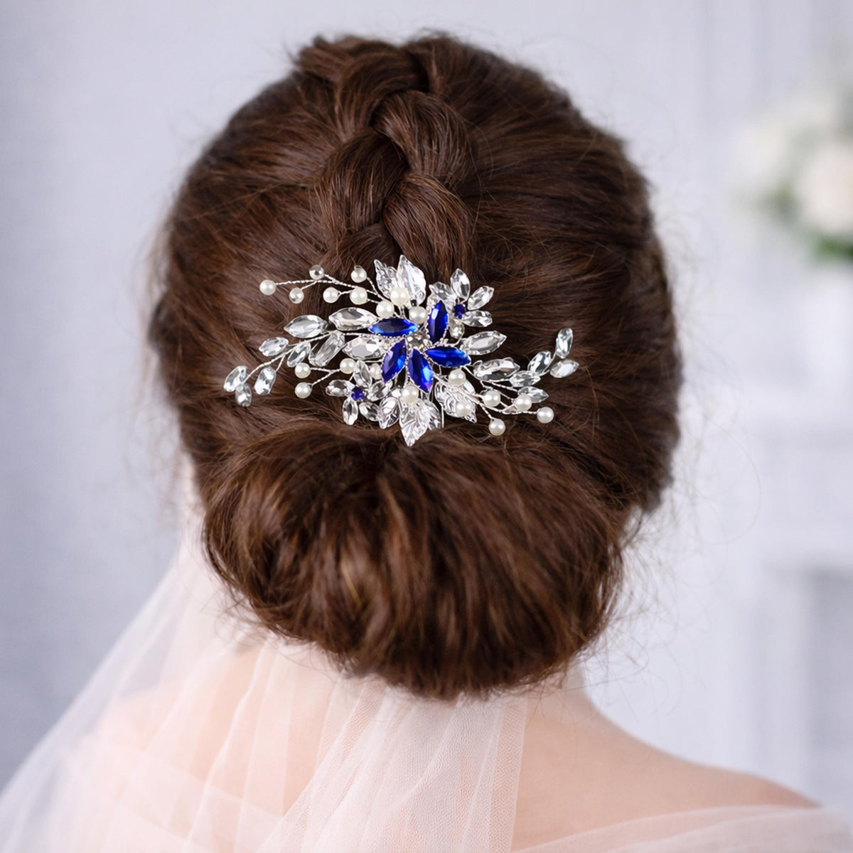 a close-up view of a woman's back, focusing on her hair and a decorative hair accessory.