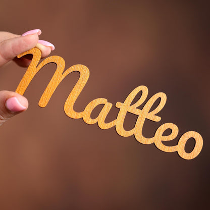 a person holding a piece of wood that says mateo