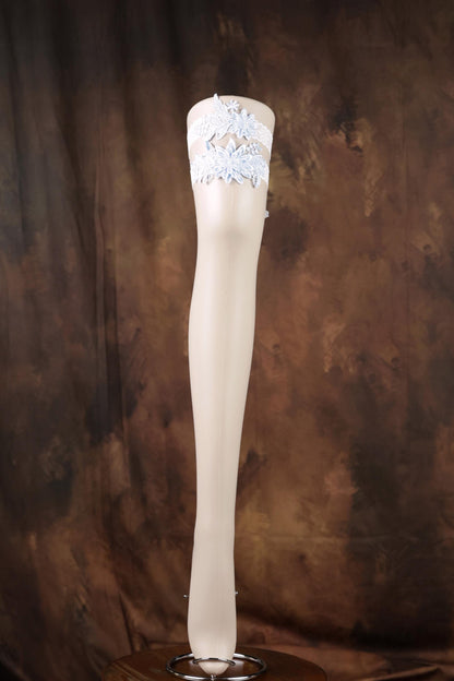 A white knee-high stocking with a decorative lace trim is displayed against a brown background.