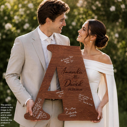 A man and a woman are holding a large wooden letter, which appears to be a wedding invitation or announcement. The man is wearing a suit, and the woman is wearing a white dress. They are smiling and looking at each other, suggesting a happy and loving relationship.