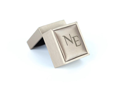 A small, square-shaped box with a beige color and a logo on it.