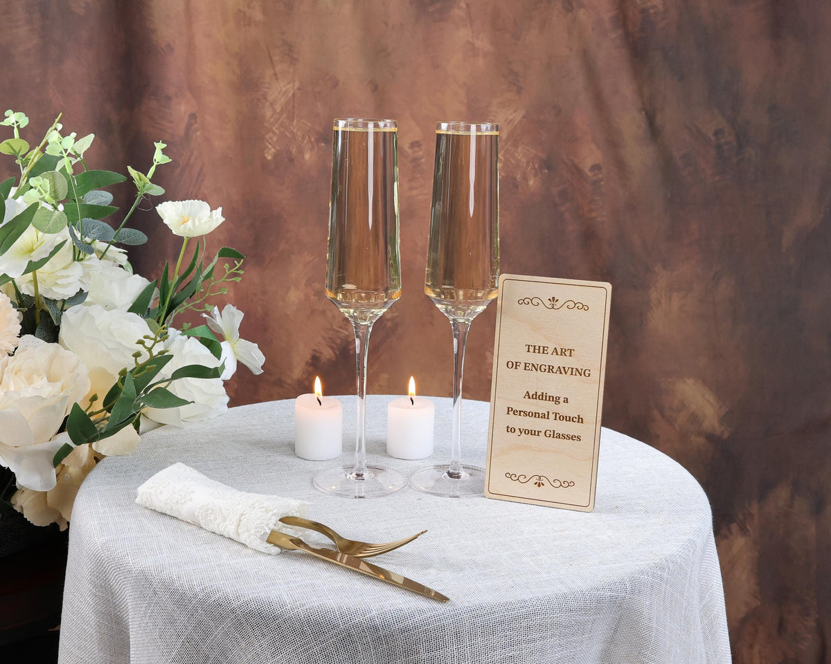 a table topped with two champagne flutes and a sign