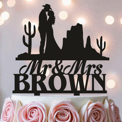 A silhouette of a couple embracing, with the words "Mr & Mrs Brown" written below, on a cake.