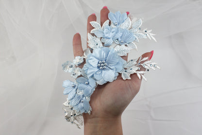 a woman's hand holding a bouquet of blue flowers
