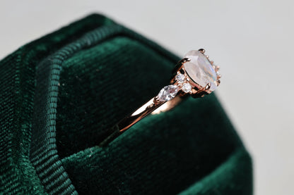 a diamond ring sitting on top of a green velvet bag