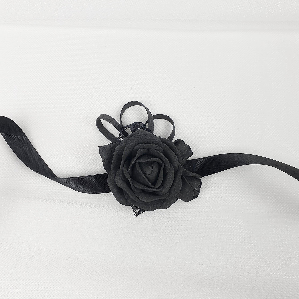 a black rose on a black ribbon on a white background