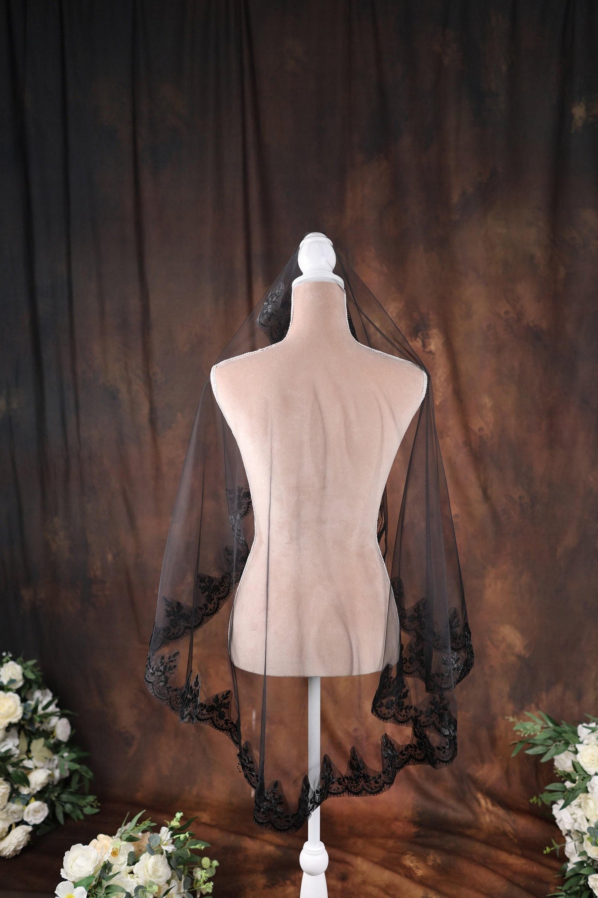 a white mannequin with a black veil on top of it
