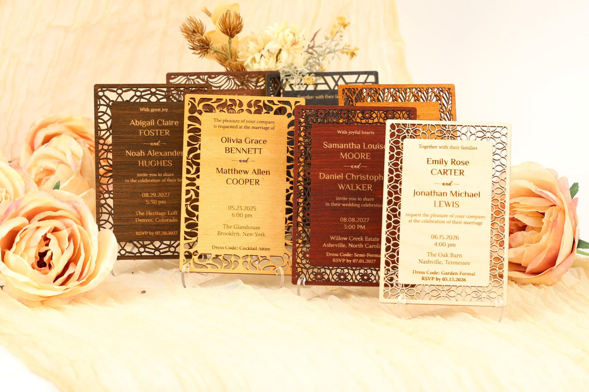a collection of wedding invitations with intricate designs, placed on a table with flowers.
