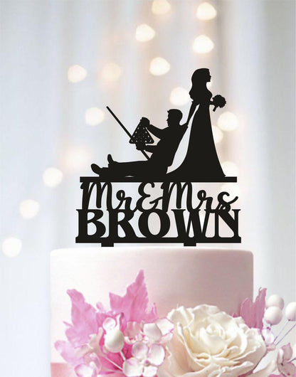 A silhouette of a man and a woman on a cake topper, with the text "Mr & Mrs Brown" below them.