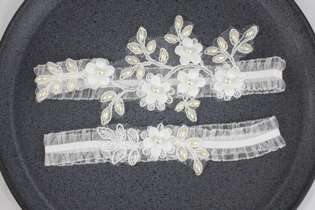 two garters with flowers and pearls on them